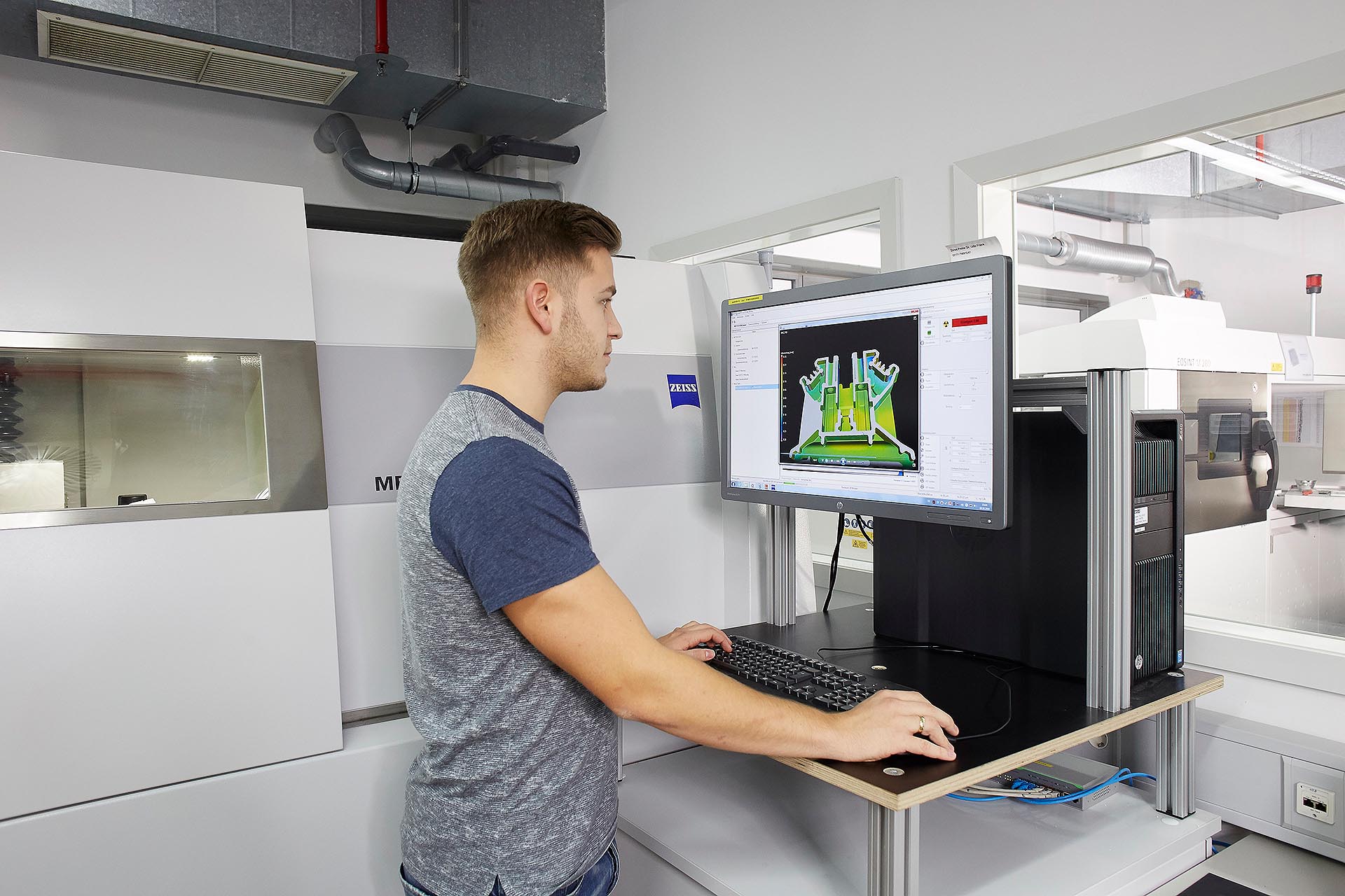 A man stands at a machine in the production hall